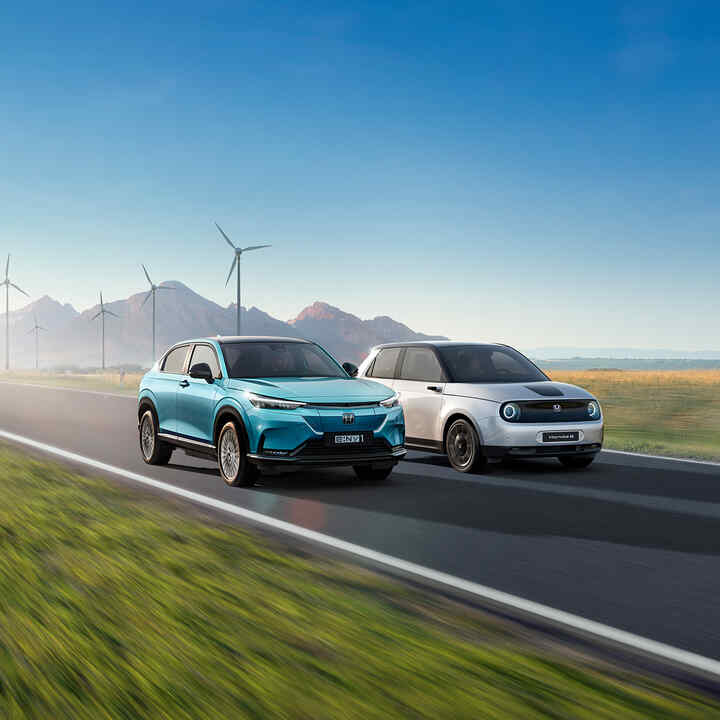 Honda e:Ny1 und Honda e vor einem Windpark.